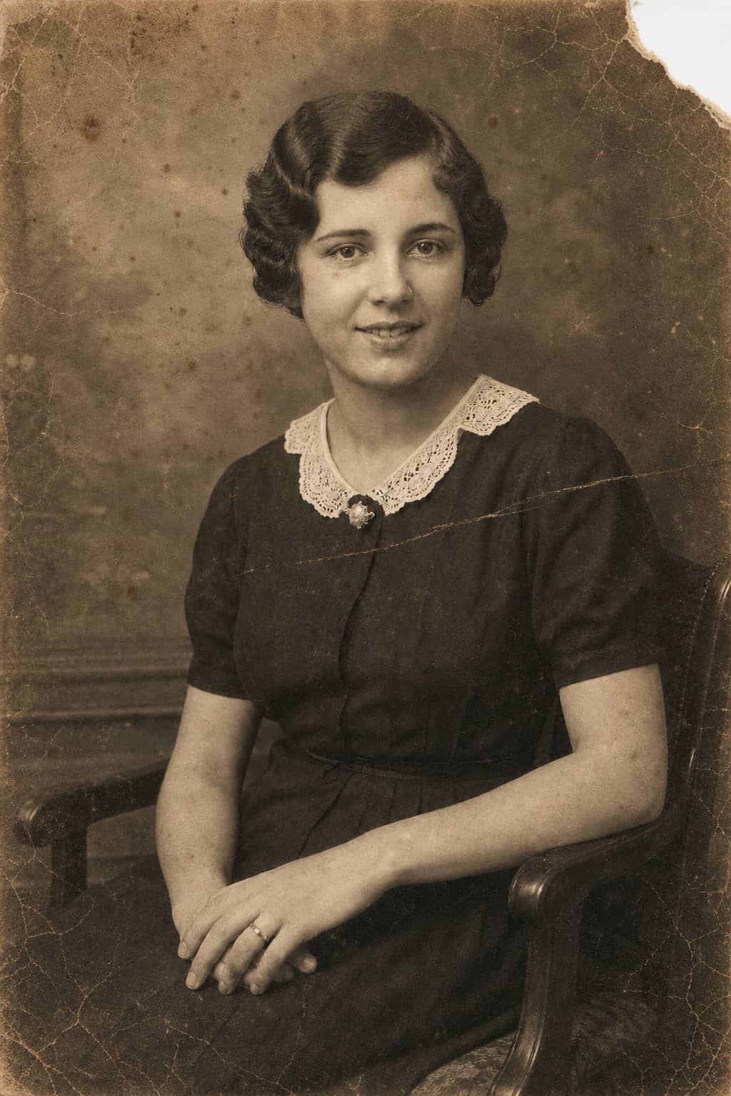 Cracked, foxed 1936 studio portrait with a broken corner before restoration.